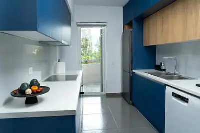 a blue and white kitchen with a bowl of fruit on the counter at Luxury apartment in Alimos in Athens