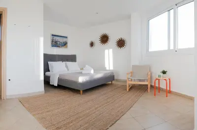 a white bedroom with a bed and a chair at Casa Acropolis - Stunning 3Br Apt with Private Terrace in Athens