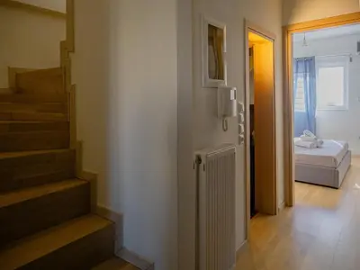 a room with a bed and a hallway with stairs at Casa Acropolis - Stunning 3Br Apt with Private Terrace in Athens