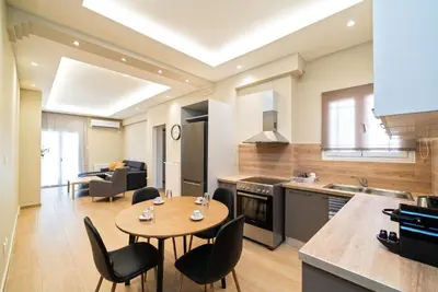 a kitchen and living room with a table and chairs at Filoxenia MG Projects Acropolis Dimitrakopulou in Athens