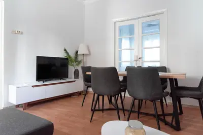 a living room with a table and chairs and a television at Thissio Getaway 2BA next to Athens ancient market in Athens