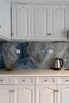 a kitchen counter with white cabinets and a tea kettle at Thissio Getaway 2BA next to Athens ancient market in Athens