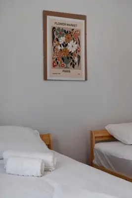 two beds in a room with a picture on the wall at Thissio Getaway 2BA next to Athens ancient market in Athens