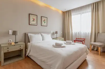 a bedroom with a large white bed and a chair at Central Athens Loft C in Athens