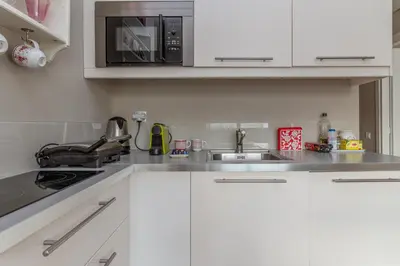a kitchen with white cabinets and a microwave at Central Athens Loft C in Athens