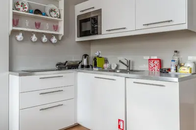 a kitchen with white cabinets and a sink at Central Athens Loft C in Athens