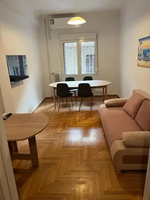 a living room with a table and a couch at Delightful 2BR Apt in the Heart of Kypseli! in Athens