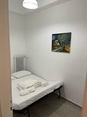 a bed in a room with a picture on the wall at Delightful 2BR Apt in the Heart of Kypseli! in Athens
