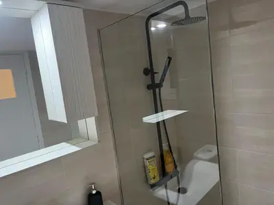 a shower with a glass door in a bathroom at Delightful 2BR Apt in the Heart of Kypseli! in Athens