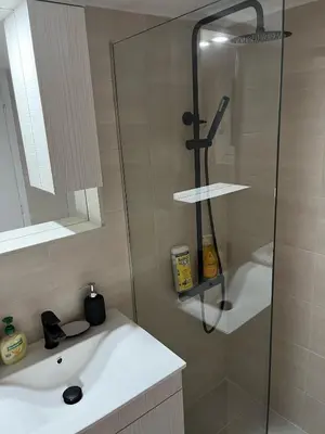 a bathroom with a shower and a white sink at Delightful 2BR Apt in the Heart of Kypseli! in Athens