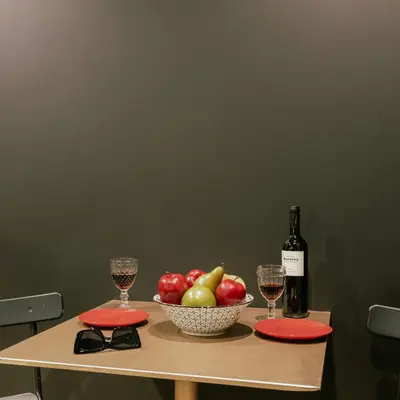 a table with a bowl of fruit and a bottle of wine at Black & Gold Tsakalof 17 by Zeussuites in Athens