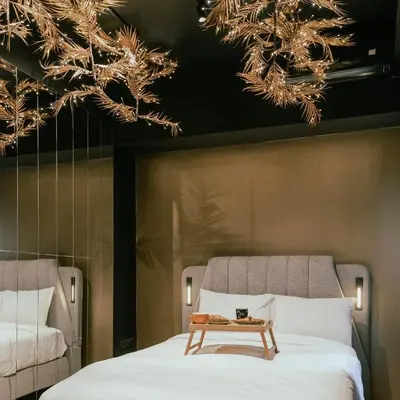 a bedroom with two beds and a table on the bed at Black & Gold Tsakalof 17 by Zeussuites in Athens