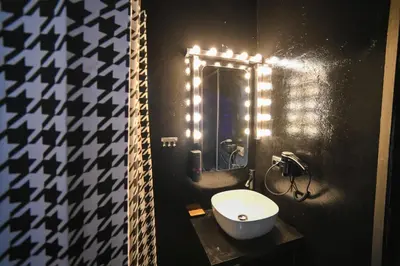 a bathroom with a white toilet and a mirror at Black & Gold Tsakalof 17 by Zeussuites in Athens