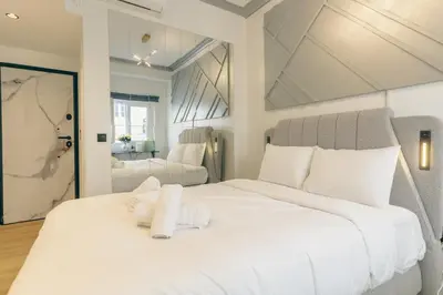 a white bedroom with a large white bed at Diamond Tsakalof 17 by Zeussuites in Athens