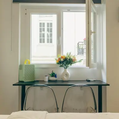 a table with two chairs in front of a window at Diamond Tsakalof 17 by Zeussuites in Athens