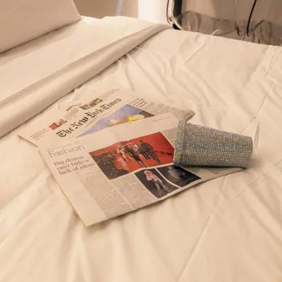 a news paper on a bed with a newspaper at Diamond Tsakalof 17 by Zeussuites in Athens
