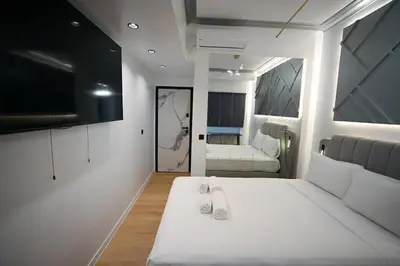 a bedroom with a large white bed and a tv at Diamond Tsakalof 17 by Zeussuites in Athens