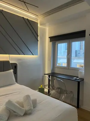 a bedroom with a bed with a desk and a window at Diamond Tsakalof 17 by Zeussuites in Athens