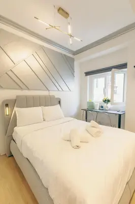a large white bed in a room with a window at Diamond Tsakalof 17 by Zeussuites in Athens