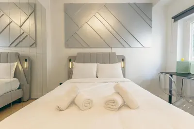 a bedroom with a large white bed with white pillows at Diamond Tsakalof 17 by Zeussuites in Athens