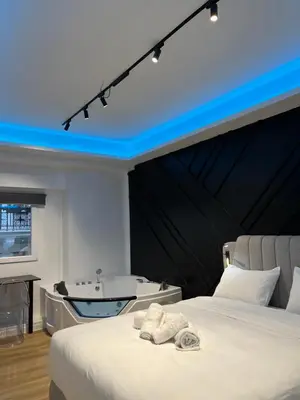 a bedroom with a bath tub and a bed at Platinum Jacuzzi Tsakalof 17 by Zeussuites in Athens
