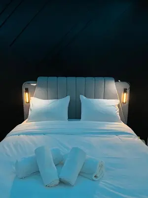 a large white bed with two blue pillows on it at Platinum Jacuzzi Tsakalof 17 by Zeussuites in Athens