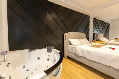 a bathroom with a large tub next to a bed at Platinum Jacuzzi Tsakalof 17 by Zeussuites in Athens
