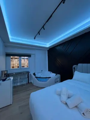 a bedroom with a white bed and a bath tub at Platinum Jacuzzi Tsakalof 17 by Zeussuites in Athens