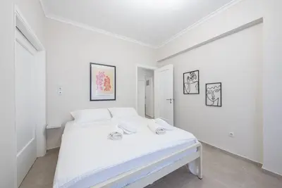 a white bedroom with a white bed in it at Athens city gem in koukaki in Athens