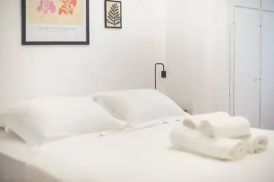 a white bed with two rolls of towels on it at Athens city gem in koukaki in Athens