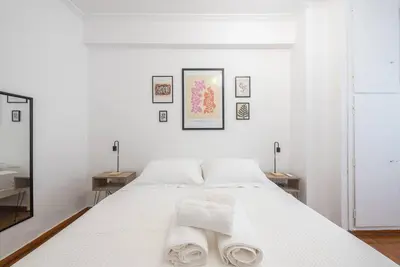a bedroom with a white bed with towels on it at Athens city gem in koukaki in Athens