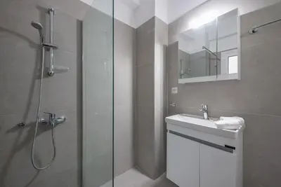 a bathroom with a shower and a sink and a mirror at Athens city gem in koukaki in Athens