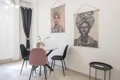 a dining room with chairs and paintings on the wall at Athens city gem in koukaki in Athens