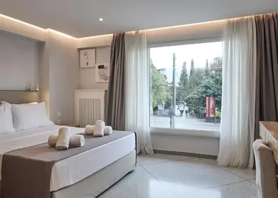 a bedroom with a bed and a large window at Bright space with street view, near Acropolis in Athens
