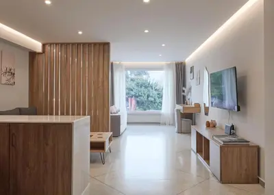 a large living room with a television and a couch at Bright space with street view, near Acropolis in Athens