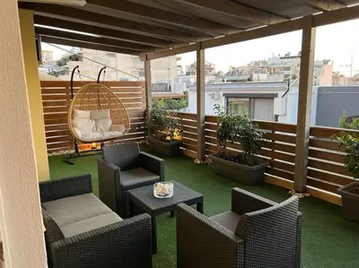 a patio with chairs and a table on a balcony at The Condo Spacious terrace Acropolis Views in Athens