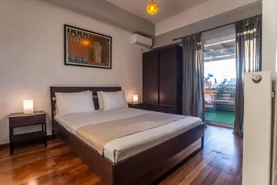a bedroom with a large bed and a large window at The Condo Spacious terrace Acropolis Views in Athens