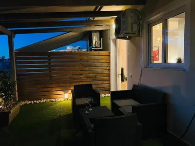 a patio with chairs and a television on a balcony at The Condo Spacious terrace Acropolis Views in Athens