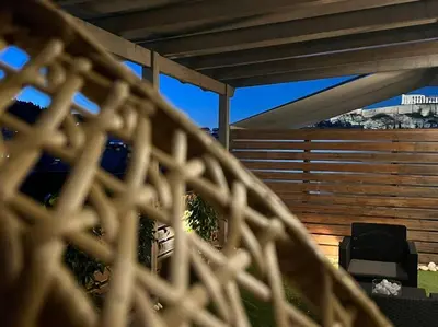 a patio with a wooden fence and a grill at The Condo Spacious terrace Acropolis Views in Athens