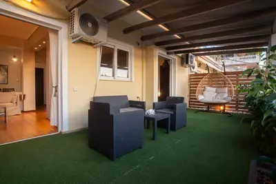 a living room with chairs and a couch and a table at The Condo Spacious terrace Acropolis Views in Athens