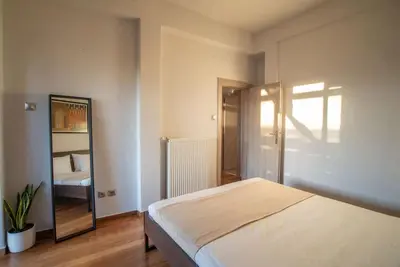 a bedroom with a large bed and a mirror at The Condo Spacious terrace Acropolis Views in Athens