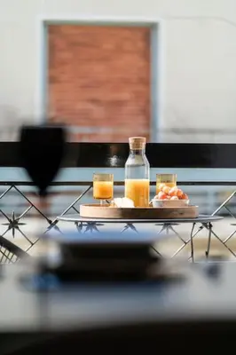 a tray with two glasses and a bottle of orange juice at Kypseli Elegant Living in Athens