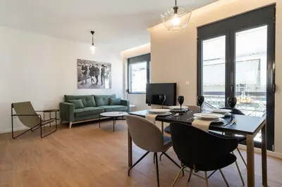 a living room with a table and chairs and a couch at Kypseli Elegant Living in Athens