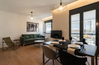 a living room with a table and a green couch at Kypseli Elegant Living in Athens