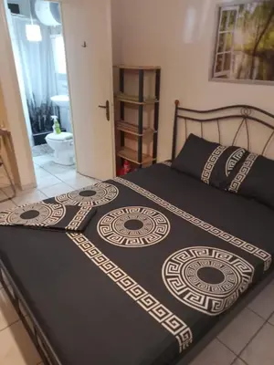 a bed with a black and white blanket on it at Athens-Koukaki in Athens