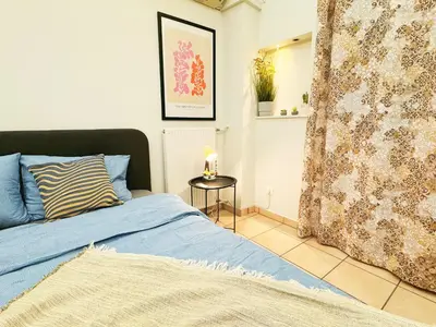 a bedroom with a blue bed and a table at Cozy Aparthotel Pangrati in Athens