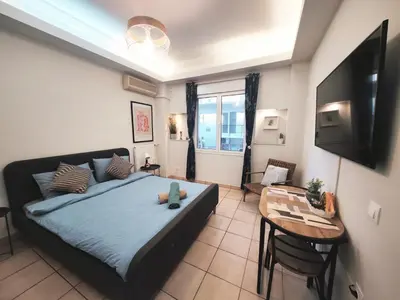 a bedroom with a bed and a table and a television at Cozy Aparthotel Pangrati in Athens