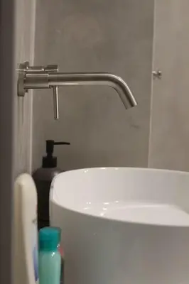 a bathroom with a sink and a faucet at Urban-chic apartment in the heart of Athens in Athens