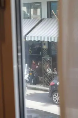 a window view of a store with a motorcycle parked in front at Urban-chic apartment in the heart of Athens in Athens
