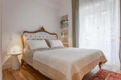 a bedroom with a bed with a white bedspread and a window at Timeless Athens Cozy Apartment in Athens